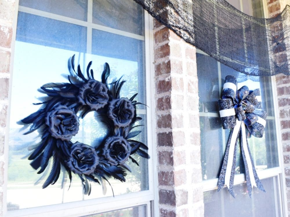 Frightful front porch modern chic halloween decorating ideas modern Halloween decor black feather wreath with black roses black and white striped bow how to decorate for Halloween