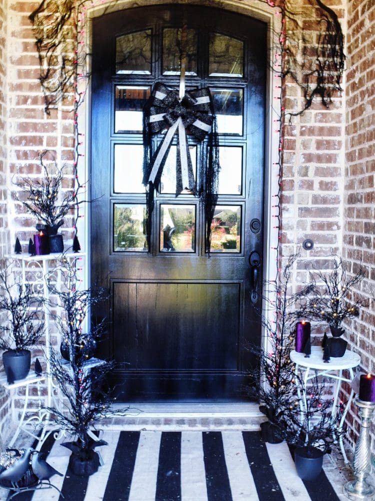 Frightful front porch modern chic halloween decorating ideas black front door with black and white LED pre lit bow modern Halloween decor