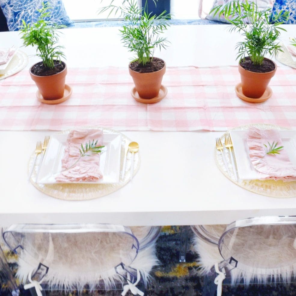 modern coastal spring decor ideas that are easy and simple using tropical neanthe bella palm plants and pink gingham table runner