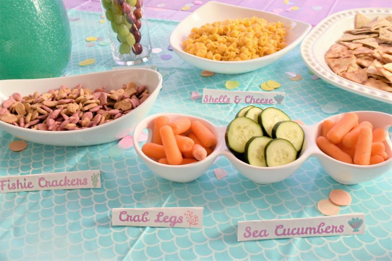 Mermaid under the sea birthday party table decor and food ideas including crab legs, fishie crackers, sea cucumbers and seaweed dip