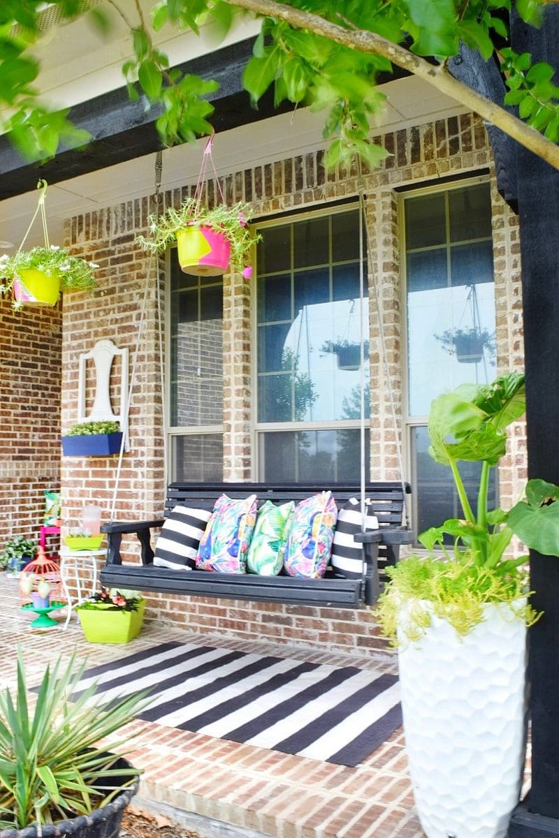 front porch swing with flower pots and hanging planters