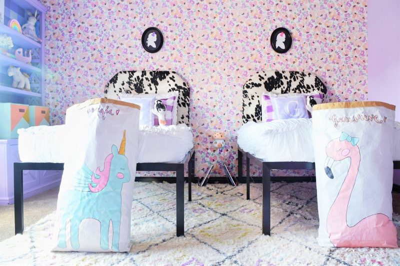 twin girls bedroom with floral wallpaper and silhouette frames