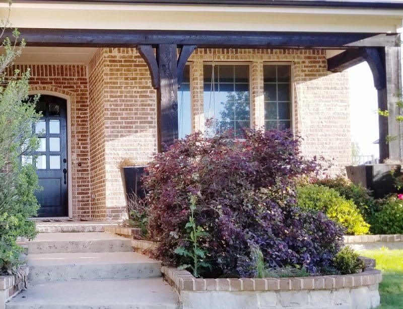 front porch and gardens of brick home