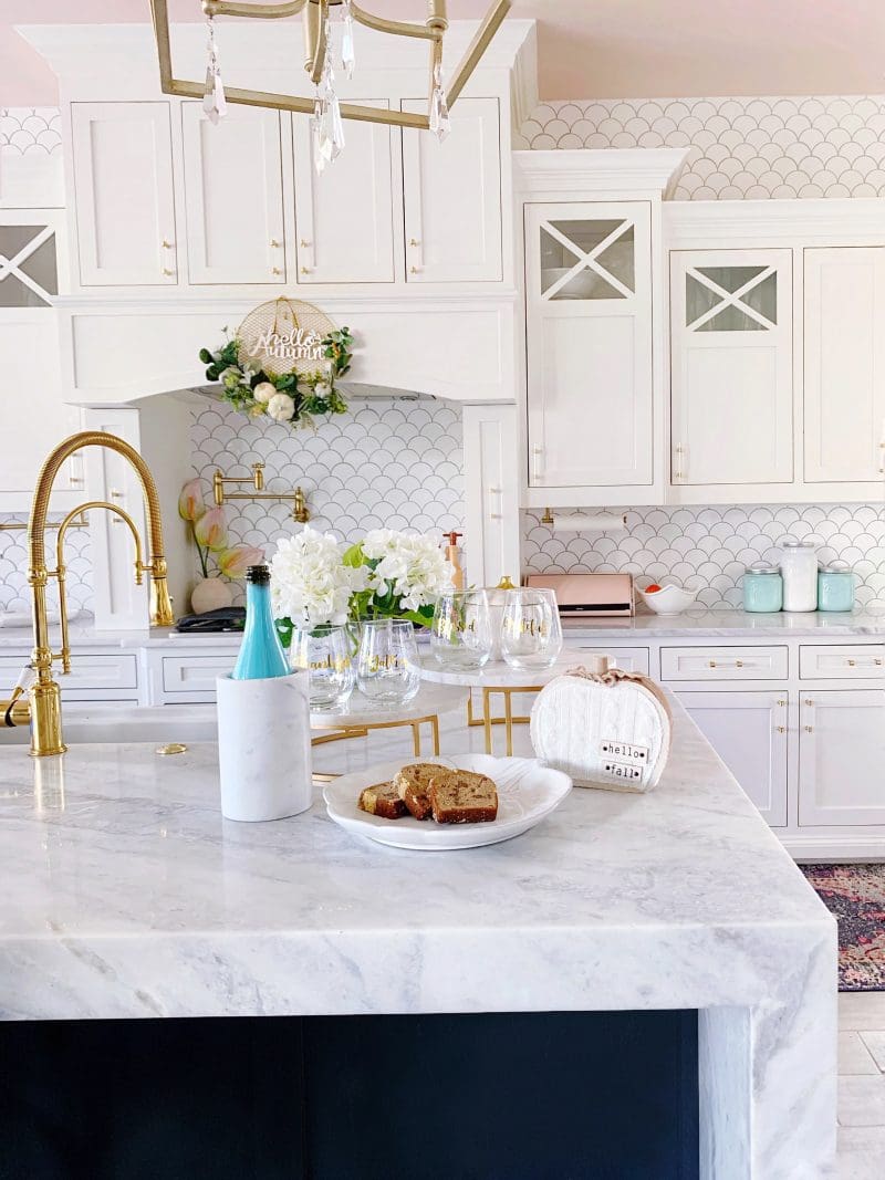 white kitchen with white cabinets and countertops with fall tabletop decor accents