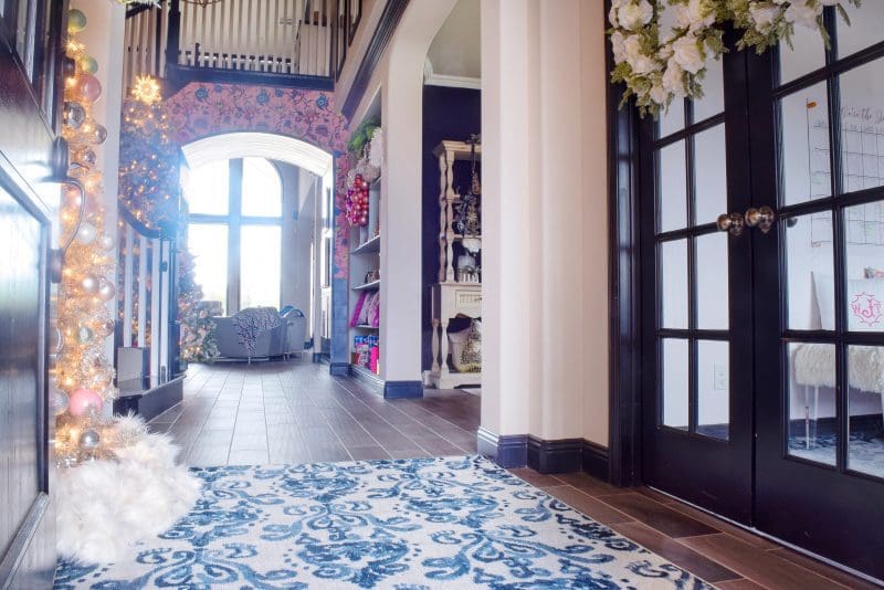 entryway with pink wallpaper and blue and white rug