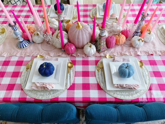 fall tablescape with pink pumpkins and blue pumpkins, pink gingham tablecloth and pink taper candle centerpiece